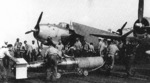 Flight deck crews of USS Wasp preparing a plywood-shrouded Mark XIII torpedo for a TBM Avenger aircraft for strikes in Taiwan-Philippine area, 13 Oct 1944; note TBM-1C Avenger and F6F-5 Hellcat