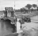 Truck moving across the Caen Canal at Pegasus Bridge, Bénouville, France, 9 Jun 1944; note grounded Horsa glider in background