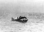 US Navy pilot Lt. (jg) John Burns, Radioman Aubrey J. Gill, and their rescued passengers awaiting rescue aboard OS2U Kingfisher aircraft, off Truk, Caroline Islands, 1 May 1944, photo 1 of 2