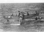 US Navy pilot Lt. (jg) John Burns, Radioman Aubrey J. Gill, and their rescued passengers awaiting rescue aboard OS2U Kingfisher aircraft, off Truk, Caroline Islands, 1 May 1944, photo 2 of 2