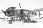 Armorers and mechanics of US 9th Air Force servicing a P-38 Lightning aircraft in the field, 1944; note external engine warmer