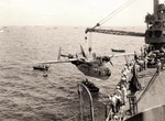 PBM-3D Mariner aircraft of US Navy patrol squadron VP-216 being hoisted onto seaplane tender USS Chandeleur, anapag harbor, Saipan, Mariana Islands, 24 Jun 1944
