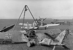 P-51 Mustang fighter being serviced at an airfield near Frankfurt, Germany, Mar-Apr 1945; note the wrecked German Fw 190 D9 aircraft in foreground