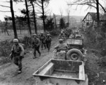Men of Company C, 1st Battalion, 18th Infantry Regiment, US 1st Infantry Division marching toward Frauwüllesheim, Germany, after crossing the Roer River, 28 Feb 1945