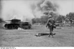 German soldier looking at a dead Soviet tanker and his burning BT-7 light tank, Jun-Jul 1941