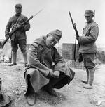 Two Chinese soldiers guarding a captured Japanese soldier, Changde, Hunan Province, China, Nov-Dec 1943