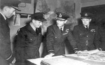 Air Vice Marshal Ralph Cochrane, Wing Commander Guy Gibson, King George VI, and Group Captain John Whitworth discussing Dambusters Raid at St Vincents Hall, headquarters of No. 5 Group RAF Bomber Command, Grantham, England, United Kingdom, 27 May 1943
