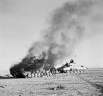 British Crusader tank passing a burning German Panzer IV tank in North Africa during Operation Crusader, 27 Nov 1941