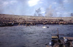 Crew of a 30 caliber machine gun watched as Americans worked on an Iwo Jima beach, 19 Feb 1945