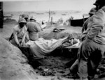 African-American US Marines carrying a Japanese prisoner of war, who was suffering from malnutrition, on a stretcher on the beach of Iwo Jima, Japan, 23 Feb 1945