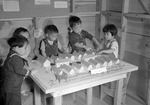 Japanese-American children playing with a scale model of their home at the Tule Lake Relocation Center, Newell, California, United States, 11 Sep 1942