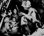 US Marine finding a family of five hiding in a cave during the fighting on Saipan, Mariana Islands, 21 Jun 1944