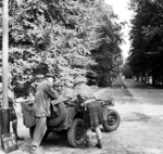 Captain Ogilvie of the UK Glider Pilot Regiment, who landed in his kilt during Operation Market Garden, preparing for a patrol next to a jeep, 18 Sep 1944