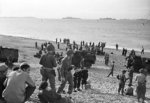 British sailors and British and American soldiers on the beach at Algiers, mid-Nov 1942; note 40-mm Bofors gun and three trucks in background