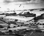 LSTs landing vehicles and cargo on a Normandy beach, June 1944, photo 1 of 2