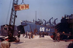A mobile crane lifted a crate in an English port, during the preparation for the Normandy invasion, circa late May or early Jun 1944