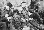 Injured men of the US 16th Infantry Regiment waited by the Chalk Cliffs for evacuation to a field hospital for further medical treatment, Collville-sur-Mer, Normandy, 6 Jun 1944