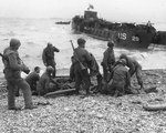 American troops administered first aid to the survivors of sunken landing craft, Normandy, 6 Jun 1944; note LCT-29 in background