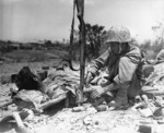 US Navy corpsman tending to a wounded US Marine, Okinawa, Japan, May 1945; note rifle as makeshift plasma holder