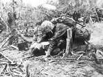 An US Marine giving his wounded comrade a drink of water from a canteen, Peleliu, Palau Islands, Sep 1944