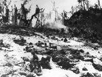 US Marines waiting in their foxholes as others blast a Japanese held cave in the nearby hill, Peleliu, Palau Islands, late Sep or early Oct 1944