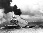 USS Maryland burning in foreground and USS Oklahoma capsizing in the back