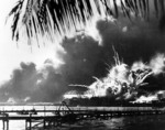 Photo capturing the moment the powder magazine of the USS Shaw exploded during the Pearl Harbor Attack, 7 Dec 1941 at about 0930. Note the after turrets of the USS Nevada passing in the channel at right.