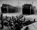Men built sandbag piers at a Leyte beach while two US Coast Guard-manned LSTs opened their cargo bay doors, circa late 1944