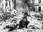 Nine-year-old Ryszard Pajewski sitting in a pile of rubble after a German raid on Warsaw, Poland, Sep 1939