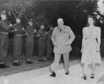 British Prime Minister Winston Churchill and his daughter Mary Churchill walking in the garden of their residence during the Potsdam Conference, Germany, 23 Jul 1945; note British Scots Guards regiment honor guard