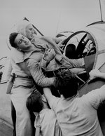 Gunner Kenneth Bratton, wounded in the knee by shrapnel, being pulled out of the turret of a TBF Avenger aircraft aboard USS Saratoga after a successful raid on Rabaul, New Britain, 5 Nov 1943