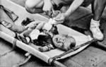 A boy scout tending to a toddler injured by Japanese bombing at South Station, Shanghai, China, 28 Aug 1937, photo 2 of 2