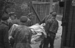 Wounded Polish insurgent fighter being evacuated from the Evangelical Cemetery, Warsaw, Poland, early Aug 1944