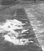 Decoy Japanese B6N, Ki-27, and other aircraft emitting false smoke during US air raid, Koshun Airfield, southern Taiwan, date unknown
