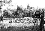 Photographer Jack Heyn of USAAF 3rd Bomb Group preparing for a group shot of airmen, Dobodura Airfield, Australian Papua, mid-1943