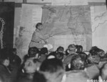 Major Louis E. Scherck briefing airmen of 40th Bomb Group, USAAF XX Bomber Command at a base in China, 14 Oct 1944; note map of Taiwan showing Takao region