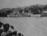 HMS Argonaut in Kiirun (now Keelung) harbor in northern Taiwan, preparing to take on former American prisoners of war, 6 Sep 1945