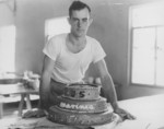 Field cook Dewitt Waite with a cake he made for USMC birthday celebration, Adams, New York, United States, 10 Nov 1943