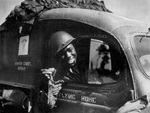 African-American US Army ambulance driver Private William A. Reynolds displaying a 0.50-cal machine gun bullet stuck in the windshield of his vehicle after German aircraft strafing, France, 1944