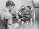 US airman painting a Flying Tigers emblem on an aircraft, China, 1940s