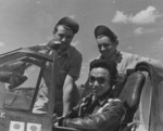 Chinese pilot in the cockpit of his airfield, with two American ground crewmen, China, 1940s