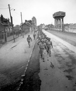 African-American soldiers of the US Army on march in Noyon, France, 28 Feb 1945
