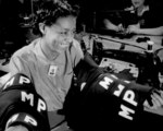 Female African-American worker making military police insignia at a factory in the United States, May 1942