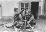 Japanese-American troops of US 442nd Regimental Combat Team firing a round of mortar, Saint-Dié-des-Vosges, France, circa late 1944