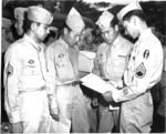 Deactivated Japanese-American soldiers of US 442nd Regimental Combat Team examining their discharge papers, Honolulu, US Territory of Hawaii, 15 Aug 1946