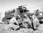 American and Chinese troops resting next to a truck in the first convoy on the Ledo Road from India and Burma into China, early 1945
