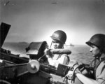 US Coast Guardsmen John Smith, African-American on left, and Daniel Kaczorowski, on right, manning a 20-mm Oerlikon autocannon aboard a landing craft, circa mid- or late-1944 off France