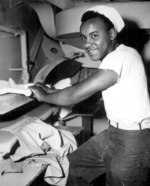 African-American US Coast Guard Seaman 1st Class Levern Robinson doing laundry aboard a troop transport in the Atlantic, circa mid-1945