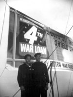 Two African-American US Maritime Service sailors posing in front of a war loan poster, Feb 1944