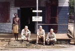 A native man and three US Navy officers at the entrance to British Solomon Islands Police Headquarters of Tulagi, 1945